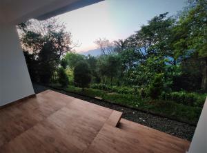 a room with a balcony with a view of trees at Peakaavu Cottages in Idukki