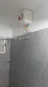 a bathroom with a shower with a camera on the wall at EMFORE ELANZA in Kottayam