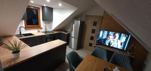 uma cozinha com uma televisão na parede numa cozinha em Apartmany Scarlett em Mýto pod Ďumbierom