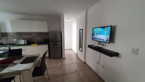 cocina con mesa y TV en la pared en Mitre apart suite en Villa María