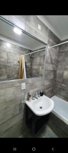 y baño con lavabo, espejo y bañera. en Mitre apart suite en Villa María