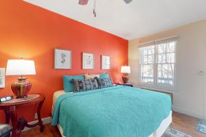 um quarto com uma parede laranja e uma cama em Bella Paradiso 04 em Eureka Springs