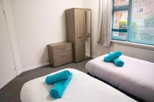 two blue pillows sitting on two beds in a room at Central City Castle Apartment with FREE parking in Nottingham