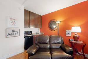 uma sala de estar com um sofá de couro e uma cozinha em Bella Paradiso 04 em Eureka Springs
