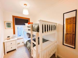 ein Schlafzimmer mit einem Etagenbett und einem Spiegel in der Unterkunft 3 Bedroom home close to town centre with WiFi & garden in Royal Tunbridge Wells