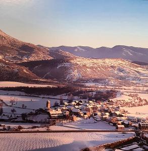 un pueblo en la nieve con montañas en el fondo en CASA PESCA VERA en Senegüé