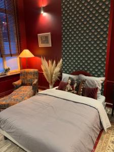 - une chambre avec un grand lit et une chaise dans l'établissement Au pied du Beffroy, à Arras