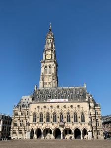a large building with a clock tower on top of it at Au pied du Beffroy in Arras