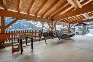 Un porche con una hamaca y una mesa en una terraza. en Raffreiderhof Apt Zirbe, en Luson