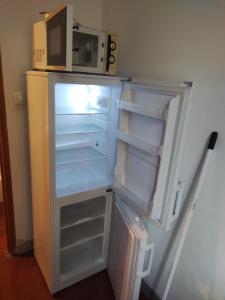 an open refrigerator with a microwave on top of it at LOUE MAISON ENTIÈRE PROPRE ! , Endroit calme, à 5 minutes gare mantes la jolie, in Mantes-la-Jolie