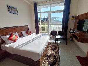 a hotel room with a bed and a large window at Blessings Always Homestay in Dehradun