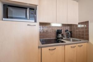 a kitchen with a microwave and a sink at Résidence Pierre & Vacances La Forêt in Flaine +47 photos