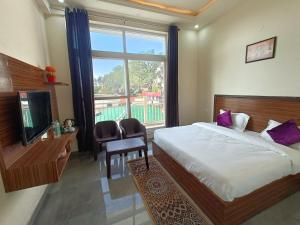 a bedroom with a bed and a television and a window at Blessings Always Homestay in Dehradun