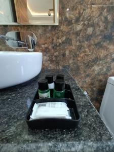 a black tray with three bottles on a bathroom counter at Blessings Always Homestay in Dehradun