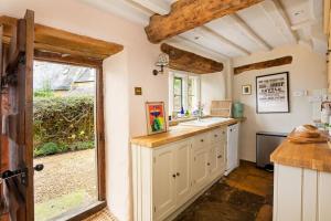 a kitchen with a sink and a large window at Charming 2BD Cottage in the Heart of Kingham! in Kingham