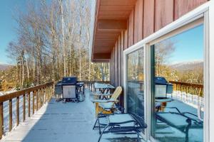 eine abgeschirmte Veranda mit Stühlen und Tischen auf einer Terrasse in der Unterkunft Bear Hill Views in Ludlow