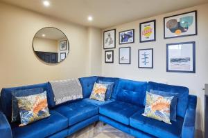 Sofá azul en la sala de estar con espejo en Host & Stay - No.33, en Tynemouth