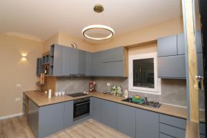 a kitchen with blue cabinets and a sink at Vila Mario Himare in Himare
