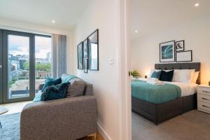 a bedroom with a bed and a chair and a window at Stylish City 1 Bed Apt - Broad St in Birmingham