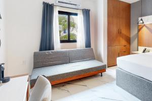 a bedroom with a couch in front of a window at Seven Boutique Unit #36 in Cancún +17 photos