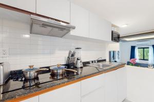 a white kitchen with two pots on the stove at Seven Boutique Unit #36 in Cancún