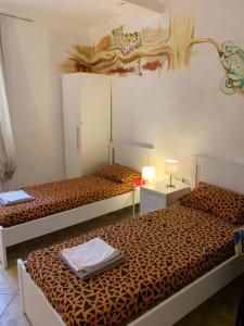 ボローニャにあるBackpackers Houseのサルの壁画が飾られた部屋のベッド2台