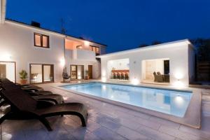 a swimming pool in the backyard of a house at Funcic Apartments 1 app in Pula