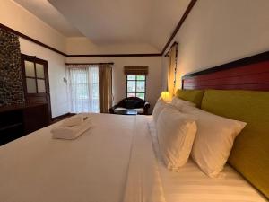 een slaapkamer met een groot wit bed met witte kussens bij Green Papaya Beach Resort, Koh Phangan in Salad Beach