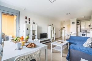 a living room with a table with a bowl of fruit at Home2Book Comfy Apartment Rambla in Las Palmas de Gran Canaria