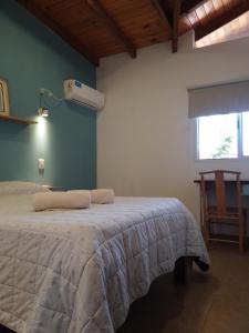 ein Schlafzimmer mit einem Bett in einem Zimmer mit einem Ventilator in der Unterkunft Complejo Quiya - Casa El Algarrobo in Alta Gracia