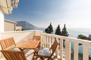 ein Balkon mit Tisch und Stühlen und dem Meer in der Unterkunft Apartments Sunrise in Brist