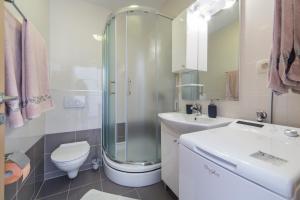 ein Badezimmer mit Dusche, Toilette und Waschbecken in der Unterkunft Apartments Sunrise in Brist + 47 Fotos