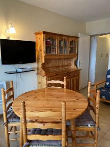 comedor con mesa de madera y sillas en Studio avec jardin et vue imprenable sur Valberg et le Saint Honorât, en Péone