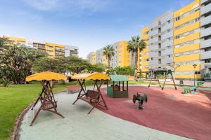 a playground with tables and chairs and a swing at Home2Book Comfy Apartment Rambla in Las Palmas de Gran Canaria