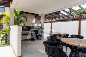 un patio con tavoli e sedie e una cucina di Barra Grande 129 a Marau