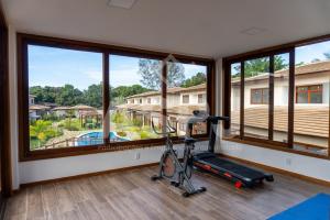 una stanza con palestra con tapis roulant e grandi finestre di Barra Grande 129 a Marau