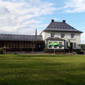 uma casa com painéis solares no telhado em Kleines Bahnhofshotel (Gästezimmer) em Greifenstein