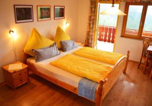 um quarto com uma cama grande com lençóis amarelos em Hansjörgenhof Bioland-Hof em Schiltach