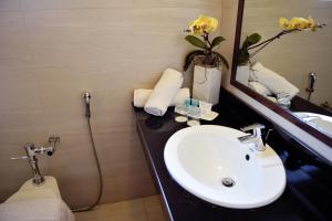 a bathroom with a sink and a toilet and a mirror at Aura One Hotel in Baguio +21 photos