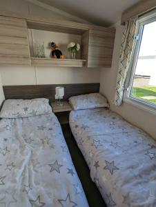 a bedroom with two beds in a trailer at Sleeps 6 Modern and bright Caravan Littlesea Haven Weymouth in Weymouth