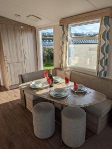 a dining room with a table and chairs at Sleeps 6 Modern and bright Caravan Littlesea Haven Weymouth in Weymouth