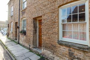 un edificio de ladrillo con una ventana en una calle en Luxury Bolthole in the Heart of the Cotswolds, en Malmesbury