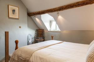 een slaapkamer met een bed en een stoel bij Luxury Bolthole in the Heart of the Cotswolds in Malmesbury