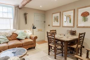 een woonkamer met een bank en een tafel bij Luxury Bolthole in the Heart of the Cotswolds in Malmesbury