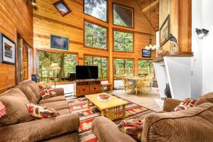 a living room with two couches and a tv at Vail Chalet in Girdwood