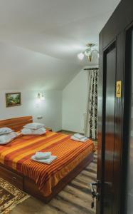 a bedroom with a large bed with orange sheets at Casa Cristina in Fundu Moldovei