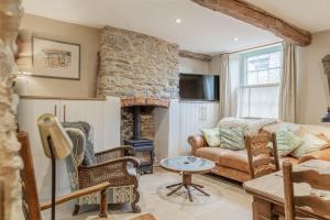 een woonkamer met een bank en een open haard bij Luxury Bolthole in the Heart of the Cotswolds in Malmesbury