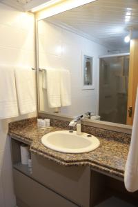 a bathroom with a sink and a large mirror at Letto Hotel Flores da Cunha in Flores da Cunha +83 photos