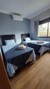 1 dormitorio con 2 camas y ventana en Casa de huéspedes Mariposa en manantial countryclub en Hohenau