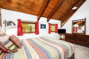 a bedroom with a large bed and red curtains at Vail Chalet in Girdwood